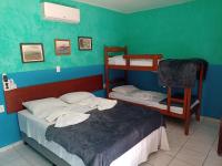 a room with two beds and a bunk bed at Pousada ZEN Cumuruxatiba in Cumuruxatiba