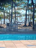 a picnic table and bench next to a swimming pool at Pousada ZEN Cumuruxatiba in Cumuruxatiba