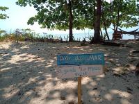 a sign in the sand on a beach at Pousada ZEN Cumuruxatiba in Cumuruxatiba