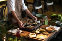 a person preparing food on a table at Rong Unique Hotel-Banyan Lake Scenery in Guilin