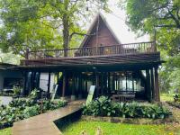 a house with a wooden deck with a balcony at Puncak Tawa Park in Tengahgirang