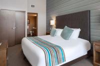 a hotel room with a large white bed with blue pillows at Sutton Place Hotel Revelstoke Mountain Resort in Revelstoke