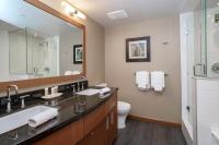 a bathroom with a sink and a toilet and a mirror at Sutton Place Hotel Revelstoke Mountain Resort in Revelstoke