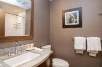 a bathroom with a sink and a toilet and a mirror at Sutton Place Hotel Revelstoke Mountain Resort in Revelstoke