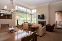 a dining room and living room with a table and couch at Sutton Place Hotel Revelstoke Mountain Resort in Revelstoke