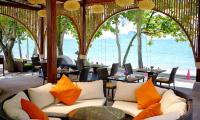 a restaurant with white couches and tables and the ocean at Aonang Villa Resort l Lifestyle Beachfront Resort in Ao Nang Beach