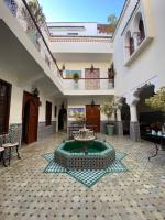 a courtyard with a fountain in the middle of a building at Riad Dar Teranga Hotel &amp; Spa in Marrakech