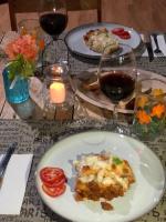 ein Tisch mit Tellern mit Essen und Gläsern Wein in der Unterkunft La Casa Colorada in San Benito