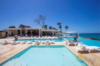 een zwembad met ligstoelen en de oceaan bij Sosua Ocean Village in Sosúa