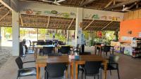 um restaurante com mesas e cadeiras em uma sala em Footprints Beach Resort em Agpudlos