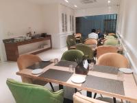 een eetkamer met tafels en stoelen met mensen op de achtergrond bij raghukul sadan in Faizābād