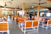 バルカラにあるHillview Beach Resortの木製のテーブルと椅子が置かれた空のレストラン