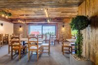 a dining room with tables and chairs and a large window at Start Skrzyczne in Szczyrk