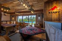 a restaurant with wooden walls and tables and chairs at Start Skrzyczne in Szczyrk