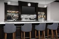 a bar with four chairs and a television at Hilton Garden Inn Jacksonville Downtown Southbank in Jacksonville