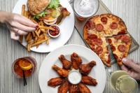 a table topped with plates of food with pizza and fries at Hilton Garden Inn Jacksonville Downtown Southbank in Jacksonville