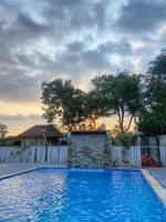 Una gran piscina azul frente a una casa en EDRIAN BUNGALOWS, en Tetebatu