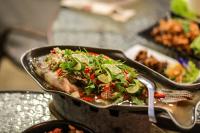 una padella piena di cibo sopra una tavola di Phuphan Resort a Ban Pa Khaem