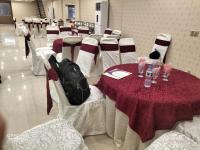 eine Gruppe von Tischen und Stühlen mit einem roten Tischtuch in der Unterkunft HOTEL DAY IN Empouriem in Lahore