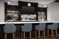Una barra con cuatro sillas y un televisor en Homewood Suites by Hilton Jacksonville-Downtown/Southbank, en Jacksonville