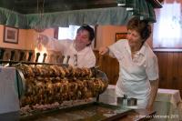 a man and a woman preparing meat on a grill at Hotel Ristorante Da Tullio in Tarzo