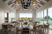 ジキル島にあるホリデイ イン リゾート ジキル アイランドのテーブルと椅子と大きな窓のあるレストラン