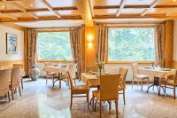 Un restaurante con mesas y sillas y grandes ventanales. en Hotel Camigliatello, en Camigliatello Silano