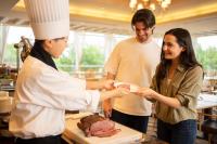 uma mulher segurando um prato de comida em uma cozinha em Hotel Associa Takayama Resort -with Natural Hot Springs- em Takayama