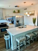eine Küche mit einer großen Kücheninsel mit zwei Hockern in der Unterkunft Luxe by the Sea - 5-Star Beachfront Escape in Myrtle Beach
