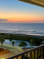 einen Balkon mit Blick auf das Meer und den Sonnenuntergang in der Unterkunft Luxe by the Sea - 5-Star Beachfront Escape in Myrtle Beach