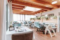 Un restaurante con mesas y sillas en una sala con techos de madera. en Adelwöhrerhof, en Falting