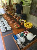 uma longa mesa de madeira com tigelas e pratos de comida em Ceylon wilpattu safaris & lodging em Parque Nacional Wilpattu