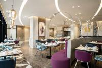 a dining room with purple chairs and tables at Mercure Riyadh Al Anoud in Riyadh