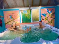 a man and a woman in a hot tub at Driftwood Country Apartment in Skibbereen