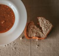 a piece of bread next to a bowl of chili at Konoba Most Rooms in Buzet