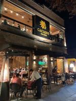 un gruppo di persone sedute al ristorante di notte di Amplo e Central Apartamento 3 Quartos a Gramado