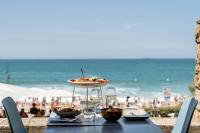 una mesa con un plato de comida en la playa en Hôtel La Suite, en Biarritz