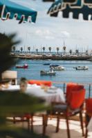 a man sitting at a table with boats in the water at Villa Cascais Boutique Hotel in Cascais