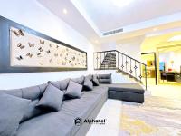 ein Wohnzimmer mit einem Sofa und einem Vogelbild in der Unterkunft Stylish 3-bedroom plus Maid room - Villa in JVC - Dubai in Dubai