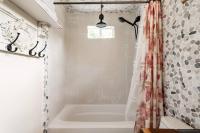 ein Badezimmer mit Badewanne und Duschvorhang in der Unterkunft Cozy Coop Casita - Lake Travis-Hot Tub-Tiny House in Austin