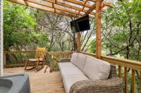 eine Veranda mit einem Sofa und einem TV auf einer Terrasse in der Unterkunft Cozy Coop Casita - Lake Travis-Hot Tub-Tiny House in Austin