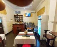 Una habitación con sala de estar con refrigerador y mesas. en DF HOTEL plazza, en Yaoundé