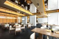 a restaurant with wooden tables and white chairs at Atour Hotel Suzhou Beisi Pagoda Taohuawu Street in Suzhou