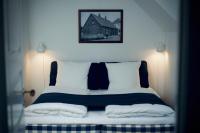 1 cama con 2 almohadas y una foto en la pared en Plesners Badehotel, en Skagen