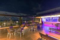 a rooftop bar with tables and chairs at night at Hotel M Pro Palace Mysore - 12 Minutes to Mysore Palace in Mysore