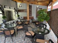 um restaurante com mesas e cadeiras em uma sala em Lux Plaza em Pʼarakʼar