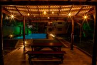 Un patio con una mesa y una piscina por la noche. en Megabe Villa, en Galle