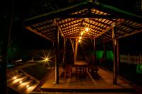 Una mesa de madera debajo de una pérgola por la noche. en Megabe Villa, en Galle