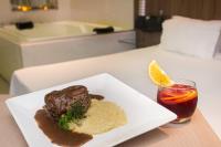 un piatto di cibo con carne e riso e una bevanda di Zapt Motel - Adults Only a San Paolo