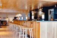 a bar with a row of stools in a restaurant at Bluebird Lake Placid in Lake Placid